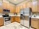 Well-lit kitchen featuring stainless steel appliances, light wood cabinetry, and bright countertops at 4737 Casswell Dr, New Port Richey, FL 34652