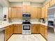 Well-equipped kitchen with wood cabinets, stainless steel appliances, and neutral countertops at 4737 Casswell Dr, New Port Richey, FL 34652