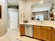 Kitchen features a stainless steel dishwasher, light wood cabinets, and an arched opening to the dining room at 4737 Casswell Dr, New Port Richey, FL 34652