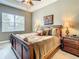 Comfortable bedroom featuring a wooden sleigh bed, a decorative painting, and lamps on the nightstands at 4737 Casswell Dr, New Port Richey, FL 34652