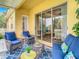 Cozy outdoor patio with comfortable seating, blue accents, and sliding glass door access at 4737 Casswell Dr, New Port Richey, FL 34652