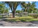 Exterior view of a mobile home with a yard and large oak tree at 12501 Holyoke Ave, Tampa, FL 33624
