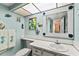 Light blue bathroom featuring a vanity and seashell decorations around the wall mirror at 4550 Cove Cir # 501, St Petersburg, FL 33708