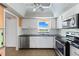 Functional kitchen equipped with stainless steel appliances, white cabinets, and granite countertops at 4550 Cove Cir # 501, St Petersburg, FL 33708