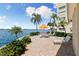 Stunning waterfront views from the patio area with comfortable seating and lush tropical landscaping at 4550 Cove Cir # 501, St Petersburg, FL 33708