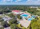 Aerial view of community pool, tennis courts, volleyball, waterpark, surrounded by lush trees at 6924 Greenhill Pl, Tampa, FL 33617