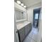 Modern bathroom featuring gray vanity with marble countertop and a separate toilet room at 6924 Greenhill Pl, Tampa, FL 33617