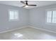 Bedroom with wood-look flooring, ceiling fan, and two windows with shutters, providing natural light at 6924 Greenhill Pl, Tampa, FL 33617