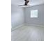Simple bedroom featuring wood-look flooring, a ceiling fan, and a window, creating a comfortable space at 6924 Greenhill Pl, Tampa, FL 33617