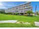 Condo building with ample parking and lush landscaping at 9510 S Harbor Greens Way # 407, Seminole, FL 33776