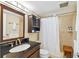 Well-lit bathroom, shower, toilet and vanity with dark wood cabinets at 12760 Indian Rocks Rd # 910, Largo, FL 33774