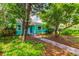 Quaint teal house with lush landscaping and a walkway at 2219 Beach S Blvd, Gulfport, FL 33707