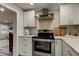 Modern kitchen with stainless steel appliances, white cabinets, and a stylish range hood at 2219 Beach S Blvd, Gulfport, FL 33707