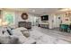 Open living area with a sectional sofa, wood floors, and large TV at 2219 Beach S Blvd, Gulfport, FL 33707