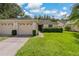 Two-car garage, light beige exterior, and well-maintained lawn at 34802 Double Eagle Ct, Zephyrhills, FL 33541