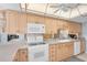 Kitchen boasts ample counter space, white appliances, and wood cabinets at 11590 Shipwatch Dr # 548, Largo, FL 33774