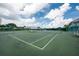 Green tennis court with a net and a covered seating area at 11590 Shipwatch Dr # 548, Largo, FL 33774