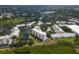 Aerial view showing a condo building nestled in a community by the water with lush landscaping at 11590 Shipwatch Dr # 548, Largo, FL 33774