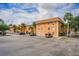 Condominium building exterior with on-site parking, tropical trees, and blue skies at 12760 Indian Rocks Rd # 510, Largo, FL 33774