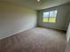 Bedroom with neutral carpet and a large window overlooking the backyard at 18208 Beach Ranch Ter, Lakewood Ranch, FL 34211