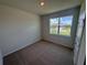 Cozy bedroom with neutral carpet and a window offering views of the neighborhood at 18208 Beach Ranch Ter, Lakewood Ranch, FL 34211