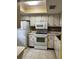 Galley kitchen with white cabinets and appliances at 601 N Hercules Ave # 103, Clearwater, FL 33765