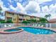 Community pool and spa with lounge chairs and surrounding building at 1513 Wharfside Dr # 1513, Tarpon Springs, FL 34689