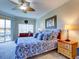 Primary bedroom with king bed, ceiling fan, and blue bedding at 1513 Wharfside Dr # 1513, Tarpon Springs, FL 34689