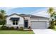 One-story home with gray siding, stone accents, and a two-car garage at 18150 Beach Ranch Ter, Lakewood Ranch, FL 34211