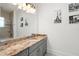 Bathroom featuring a granite countertop, vanity with storage, and a large mirror at 10603 Low Oak Ter, Thonotosassa, FL 33592