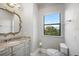 Bright bathroom with granite countertops, gray cabinetry, and a view to the backyard at 10603 Low Oak Ter, Thonotosassa, FL 33592