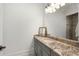 Bright bathroom featuring a granite countertop vanity, with framed art, and a shower at 10603 Low Oak Ter, Thonotosassa, FL 33592