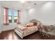 Charming bedroom featuring hardwood floors, a comfortable bed, and a bright window with natural light at 10603 Low Oak Ter, Thonotosassa, FL 33592