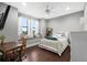 Bright bedroom featuring a window seat, hardwood floors, and comfortable bed at 10603 Low Oak Ter, Thonotosassa, FL 33592
