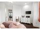 Cozy bedroom featuring hardwood floors, a dresser, and a mounted TV at 10603 Low Oak Ter, Thonotosassa, FL 33592