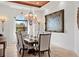 Formal dining room with chandelier, grand artwork, seating for eight, and outdoor view at 10603 Low Oak Ter, Thonotosassa, FL 33592