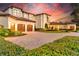 Elegant estate showcasing its impressive architecture, multi-car garage, and meticulously landscaped surroundings at 10603 Low Oak Ter, Thonotosassa, FL 33592