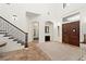 Elegant foyer featuring high ceilings, tile floors, staircase, and wood doors at 10603 Low Oak Ter, Thonotosassa, FL 33592
