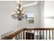 Foyer chandelier with iron railing detail, arched window, and wood entry door at 10603 Low Oak Ter, Thonotosassa, FL 33592