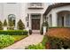 Elegant front entrance with stone columns, a brick walkway, manicured landscaping, and a grand door at 10603 Low Oak Ter, Thonotosassa, FL 33592