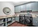 Spacious laundry room with modern washer and dryer, ample storage cabinets, and granite countertops at 10603 Low Oak Ter, Thonotosassa, FL 33592