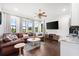 Spacious living room featuring hardwood floors, leather sofa, and views of the golf course at 10603 Low Oak Ter, Thonotosassa, FL 33592
