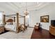 Spacious main bedroom boasts a four-poster bed, sitting area, and elegant decor at 10603 Low Oak Ter, Thonotosassa, FL 33592
