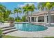 Backyard pool area surrounded by landscaping, palm trees, and an outdoor living space at 10603 Low Oak Ter, Thonotosassa, FL 33592