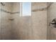 Modern shower featuring neutral tile with decorative accents, a built-in shelf, and chrome fixtures at 10603 Low Oak Ter, Thonotosassa, FL 33592