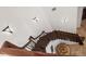 Overhead shot of a decorative wooden staircase with metal railings, ornate sconces, and travertine tile floors at 10603 Low Oak Ter, Thonotosassa, FL 33592