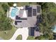 Stunning home aerial view with solar panels, pool, mature landscaping, and a private backyard oasis at 411 Harbor View Ln, Largo, FL 33770
