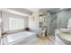 Relaxing bathroom with a soaking tub, walk-in shower, and stylish tile accents at 411 Harbor View Ln, Largo, FL 33770