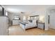 Spacious bedroom with light wood flooring, wooden bed frame, and rustic white dressers at 411 Harbor View Ln, Largo, FL 33770