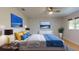 Comfortable bedroom featuring stylish lamps, ocean artwork and a modern ceiling fan at 411 Harbor View Ln, Largo, FL 33770